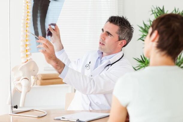 lekarz pokazuje uszkodzenie kręgosłupa z powodu osteochondrozy szyjnej